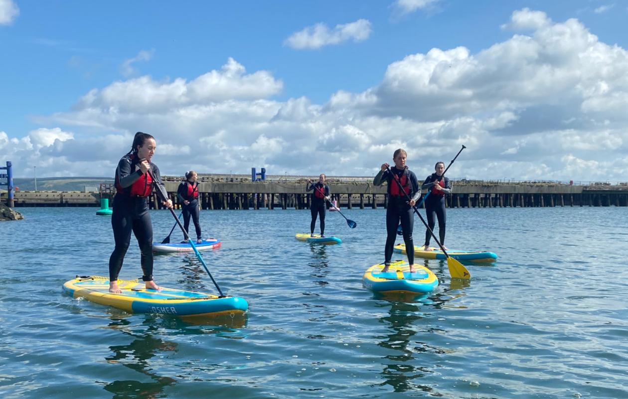group trying stand up paddle boarding